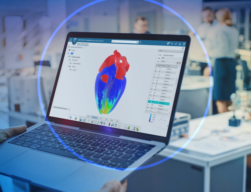Laptop displaying 3D heart model in office.