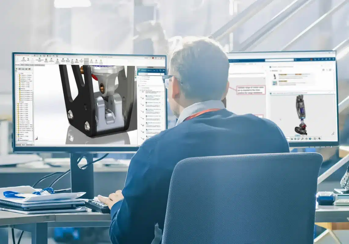 Engineer reviewing 3D CAD model on dual monitors