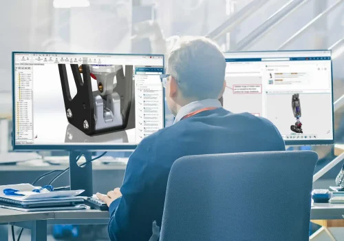 Engineer reviewing 3D CAD model on dual monitors