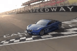 A blue sports car is on the track