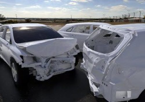White cars in a staged crash test.