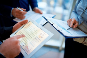 A group of people sitting around a table with papers.