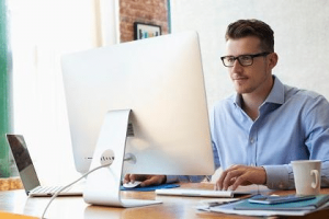 A man sitting at a table with a computer.
